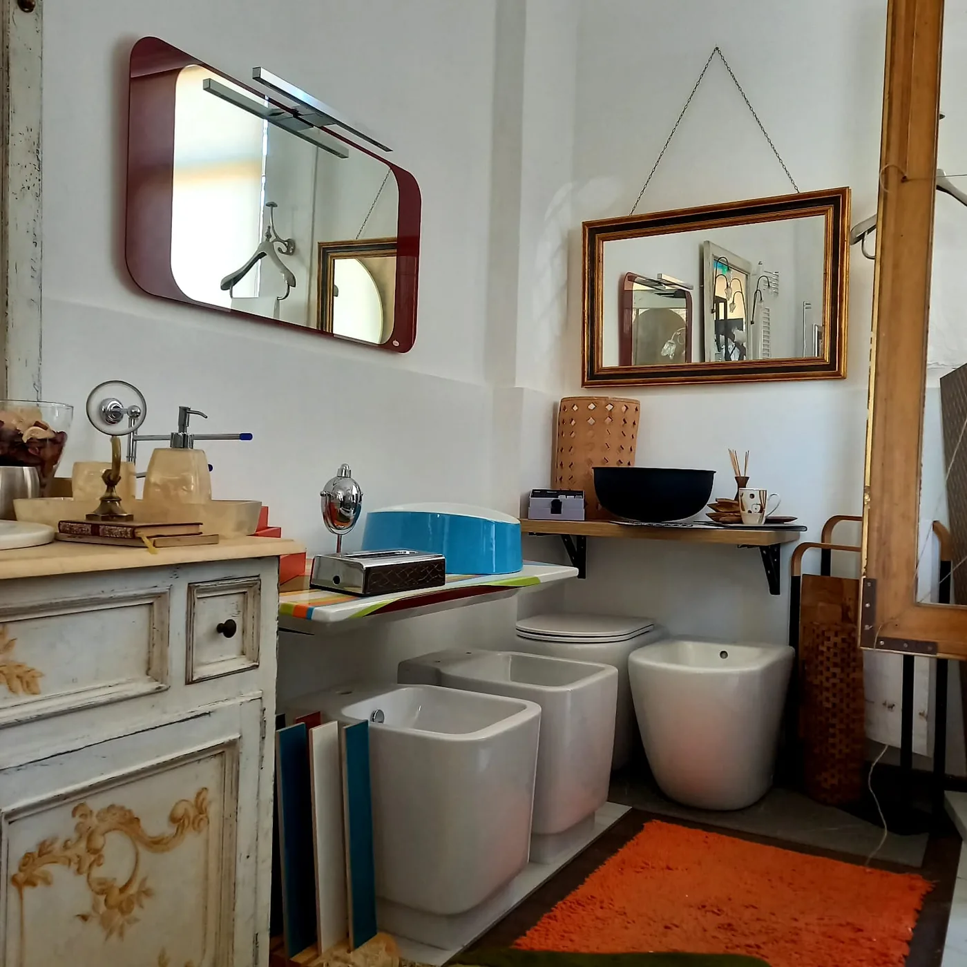 Ambiente espositivo con specchi di design, lavabi e dettagli d'arredo